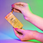 Imagen de una mano extrayendo la ampolla isdinceutics instant flash de la caja